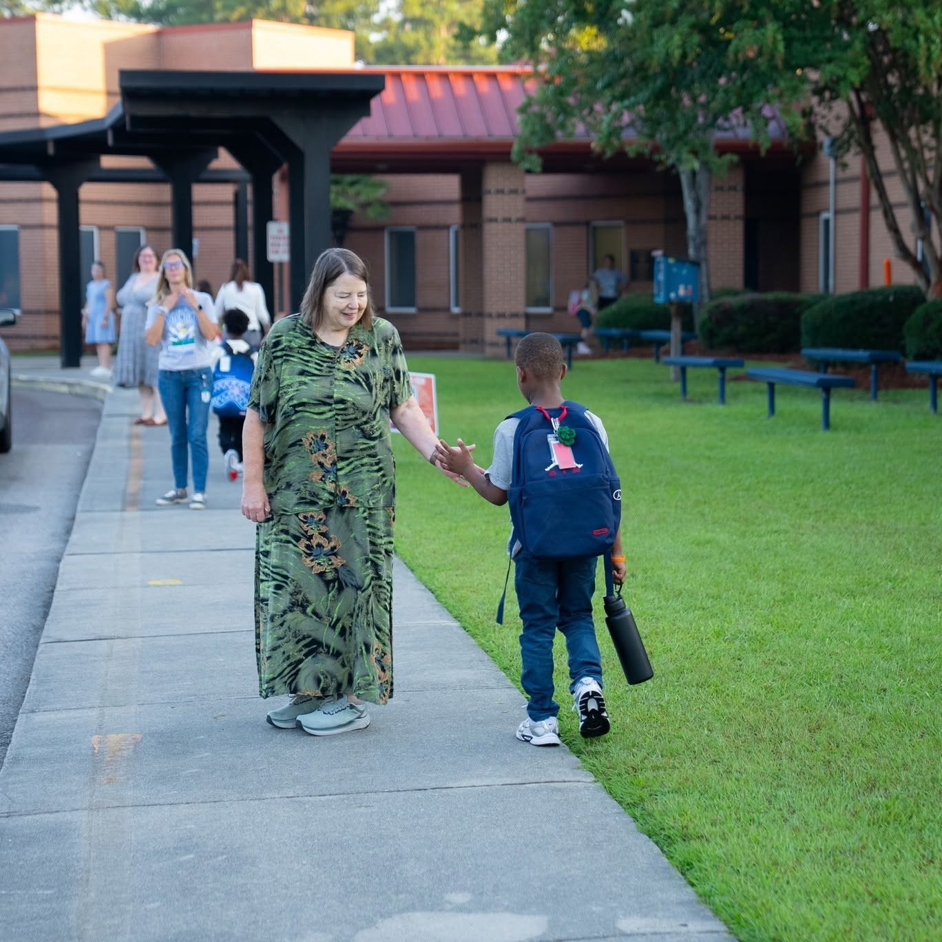 Kathy Littleton greeting a student on the sidewalk outside a Berkeley County school